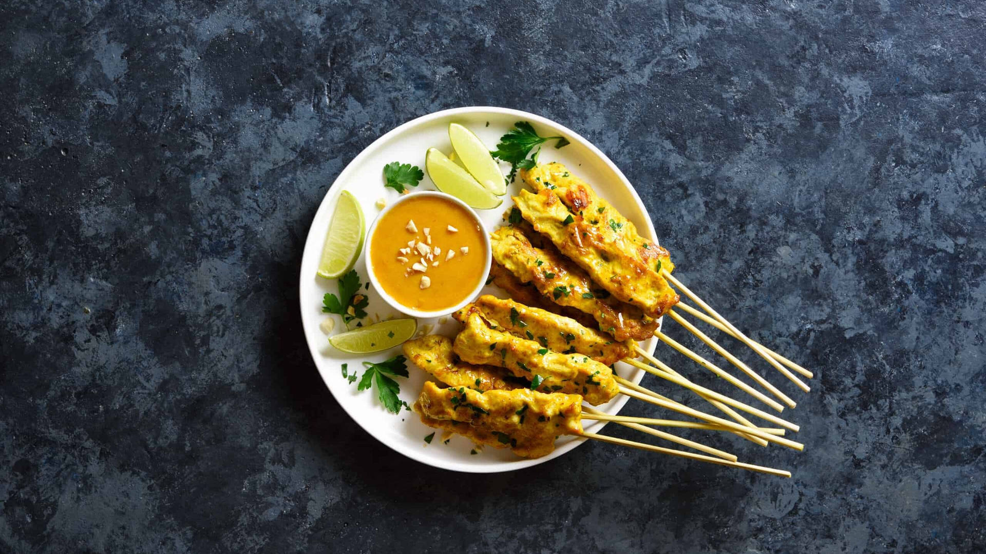 Delightful Chicken Satay With Savory Peanut Sauce And Fresh Cucumber Salad Wallpaper