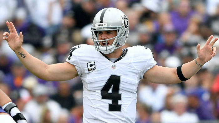 Derek Carr In White Raising His Arms Wallpaper