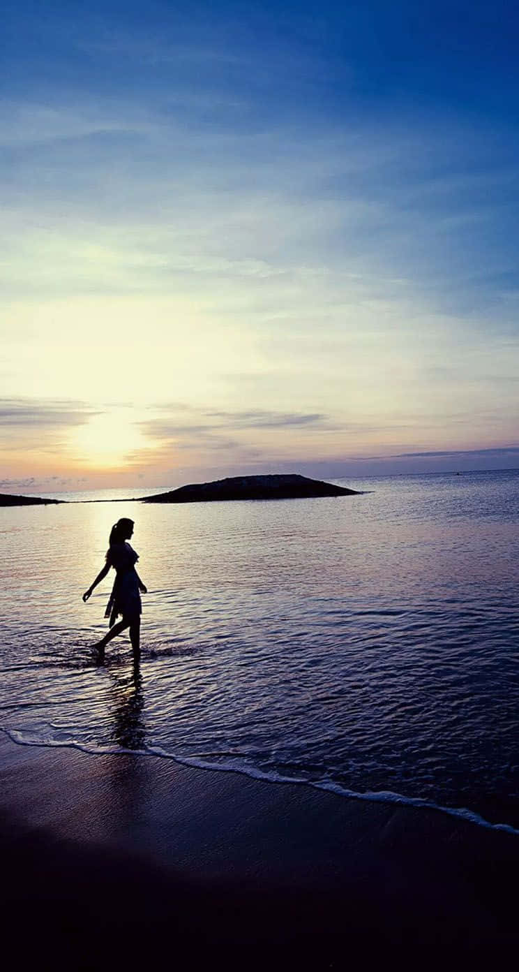 Enjoy The Beautiful Sunset At The Beach On Your Iphone Wallpaper