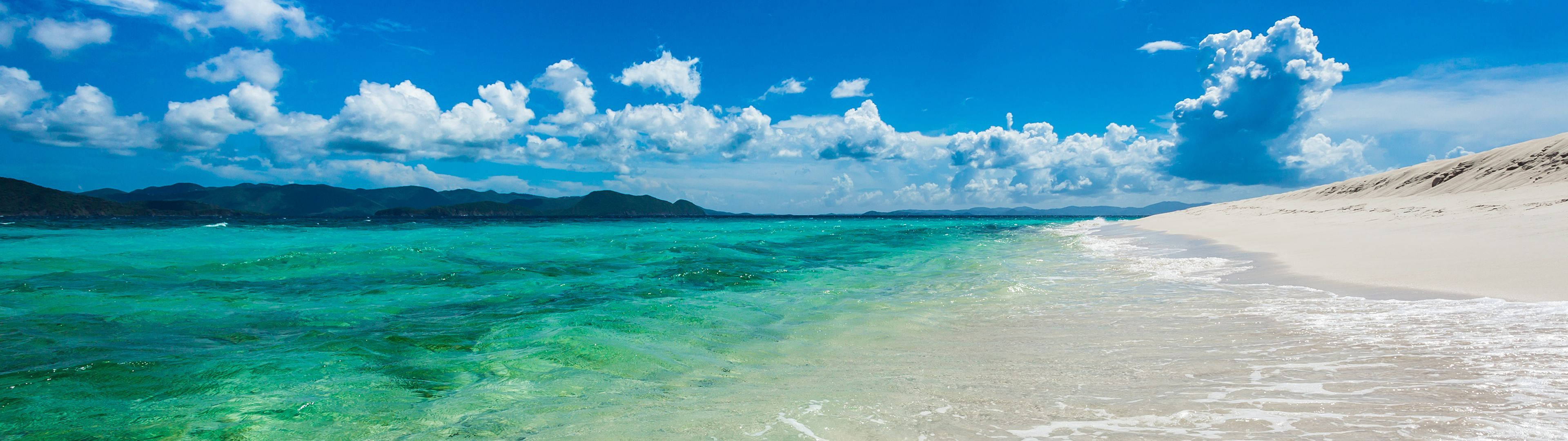 Enjoying An Idyllic Ultra-wide View Of A White Sand Beach. Wallpaper