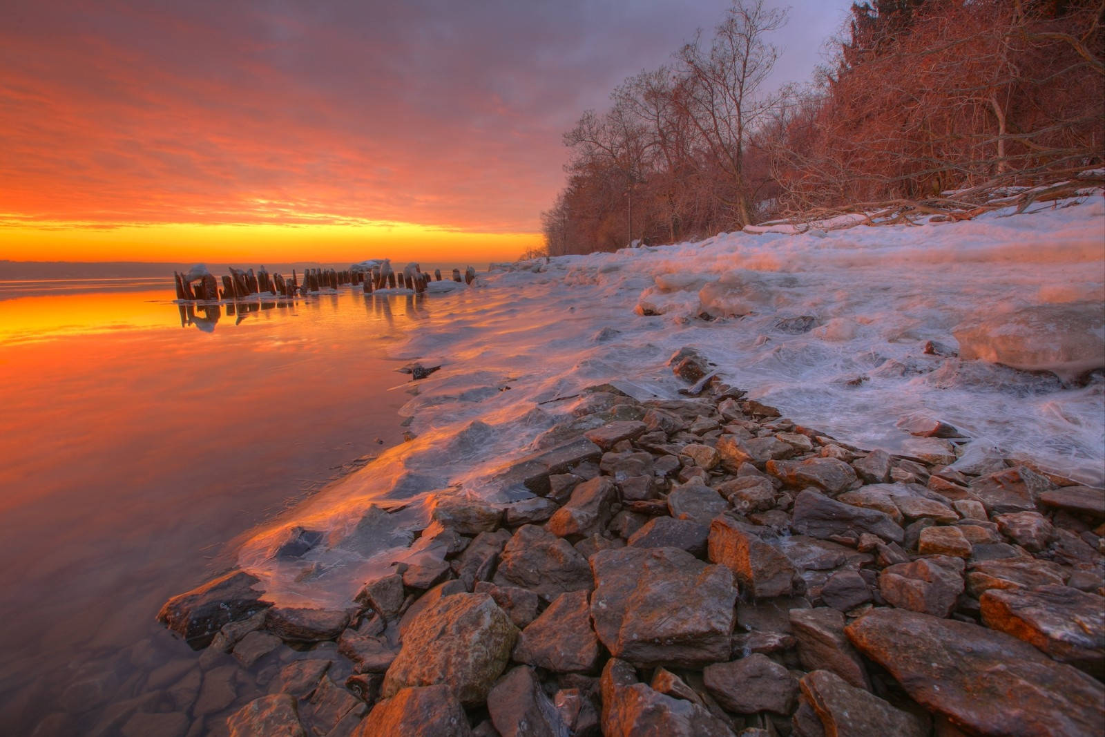 Enjoying The Sunset Over A Stone Seashore Wallpaper