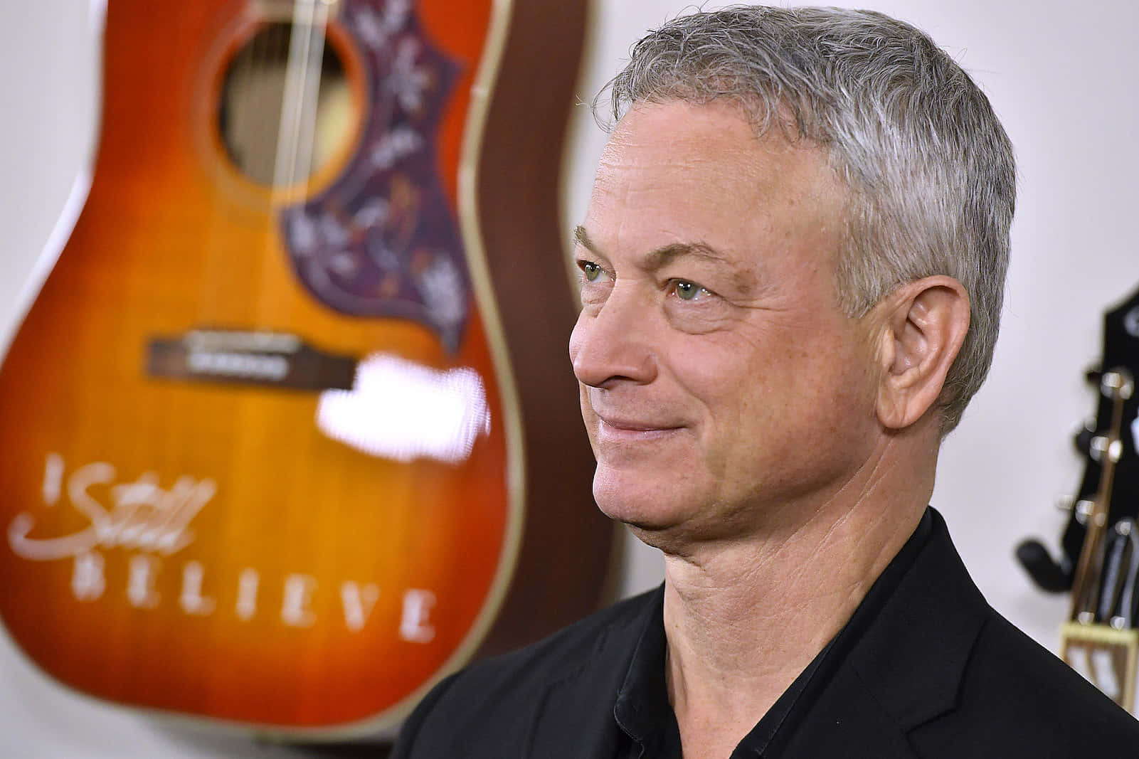 Gary Sinise Side Profilewith Guitar Background Wallpaper