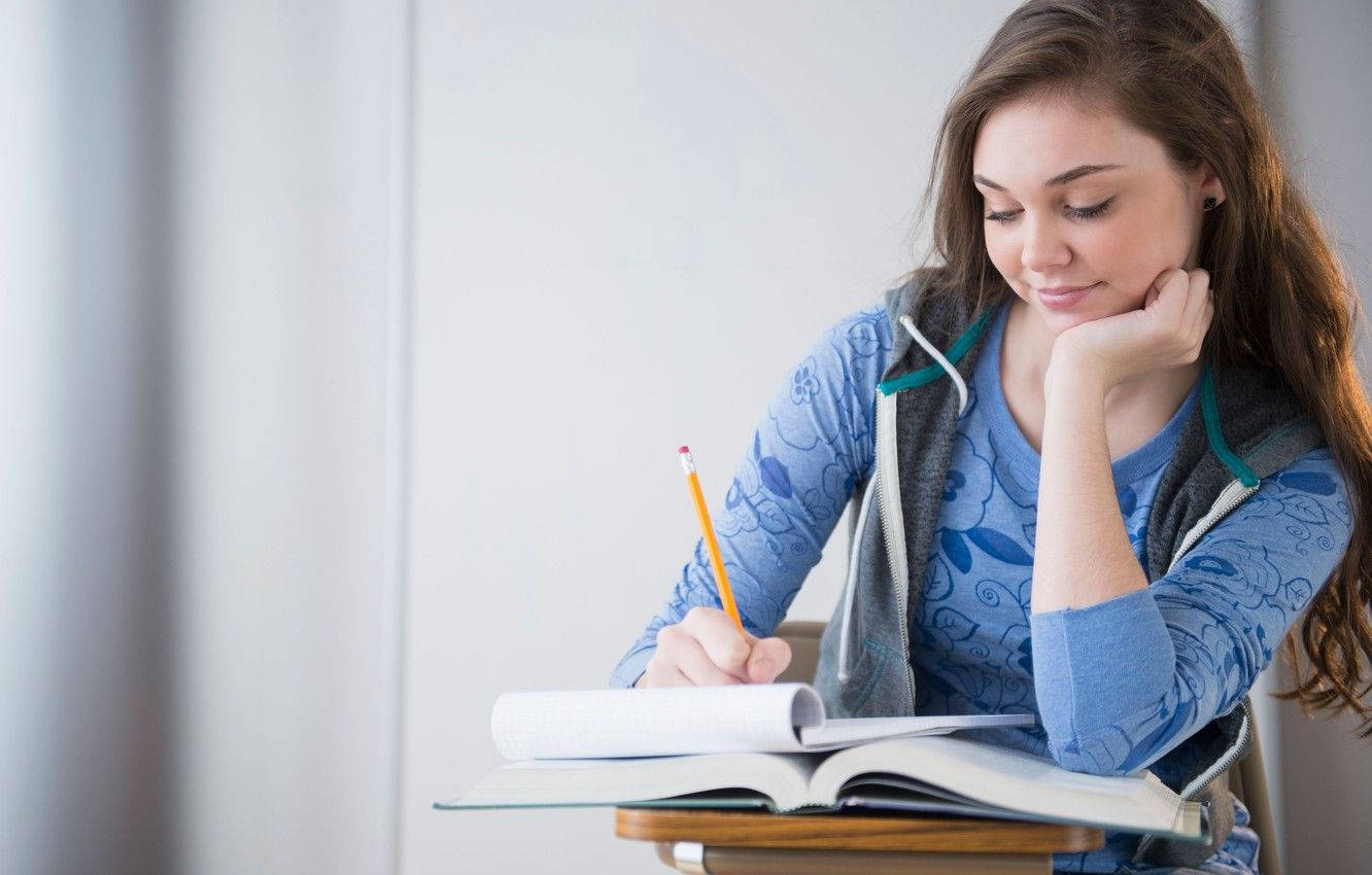 Girl Smiling While Studying Wallpaper