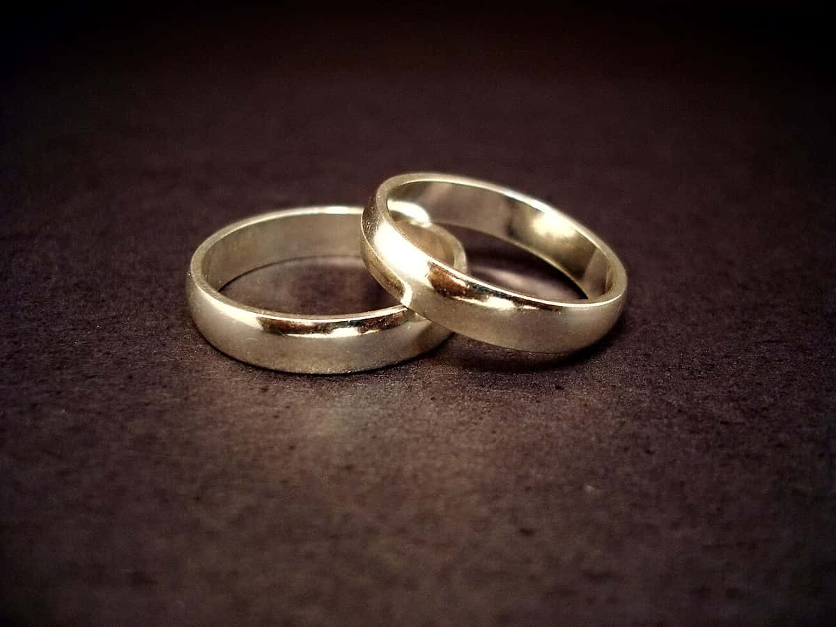 Golden Wedding Ring On Textured Surface Wallpaper