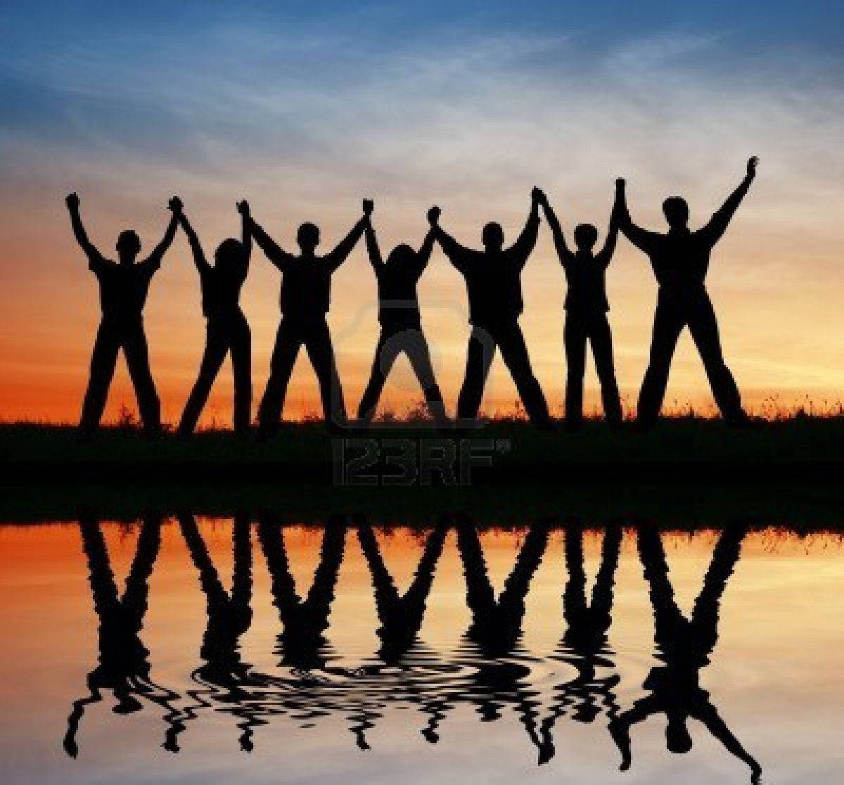 Group Raising Hands At Sunset Wallpaper