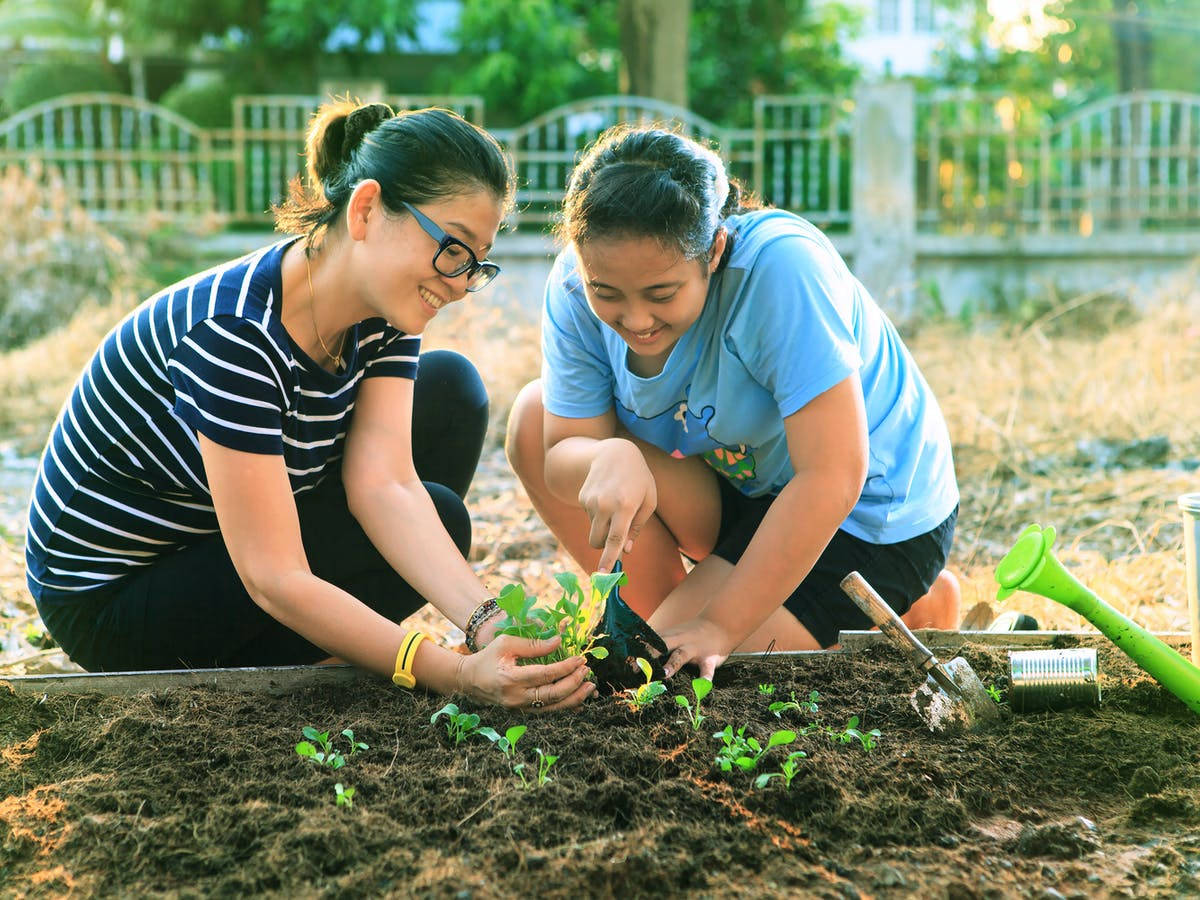 Happy Mother And Daughter Gardening Wallpaper