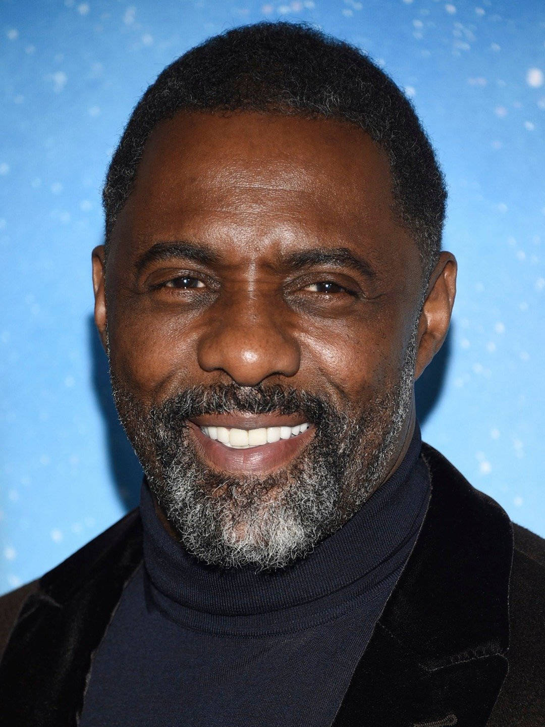 Idris Elba Posing Against A Scenic Blue Background Wallpaper