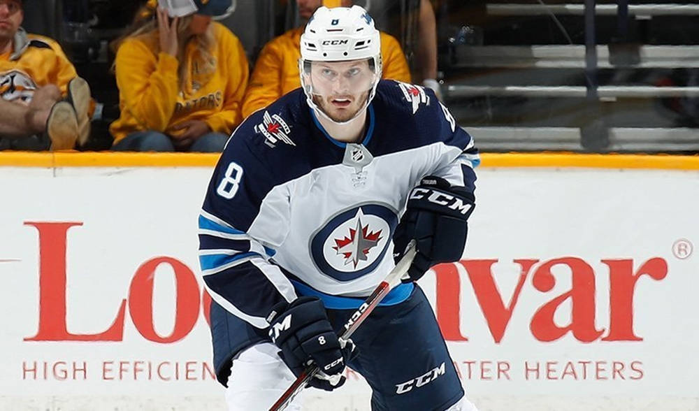 Jacob Trouba Leaning Forward While Holding Hockey Stick Wallpaper