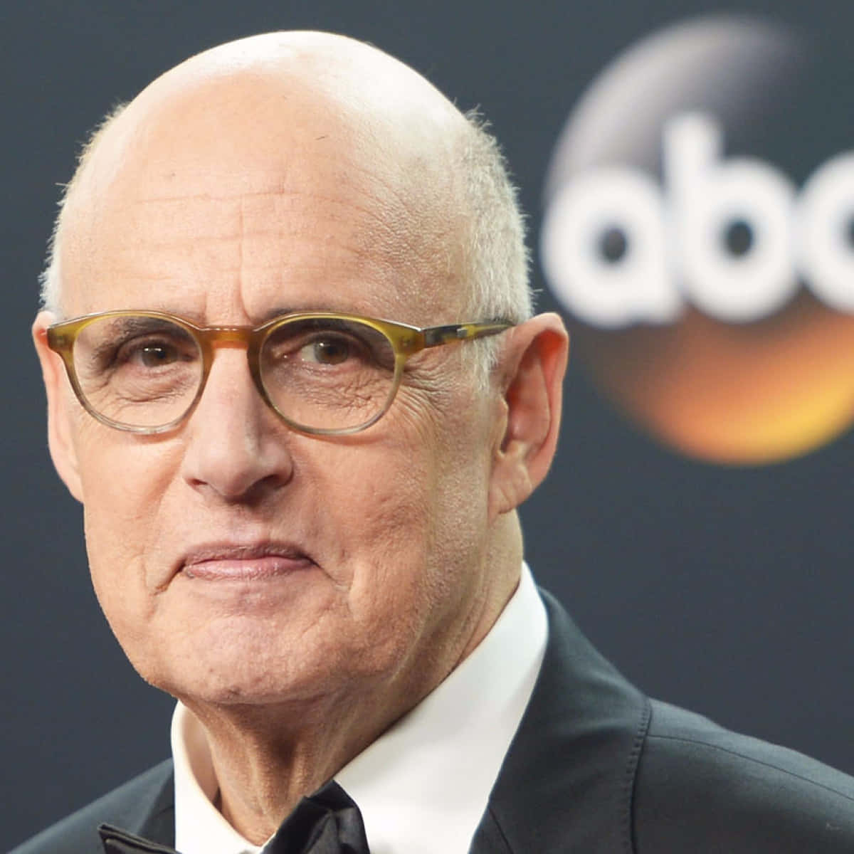 Jeffrey Tambor Captivating A Dramatic Pose Against A Backdrop. Wallpaper