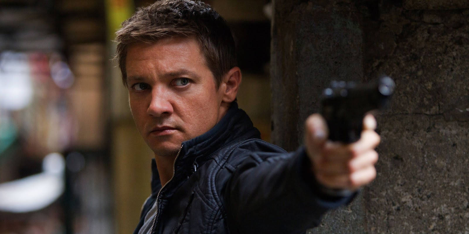 Jeremy Renner Pointing A Pistol Wallpaper