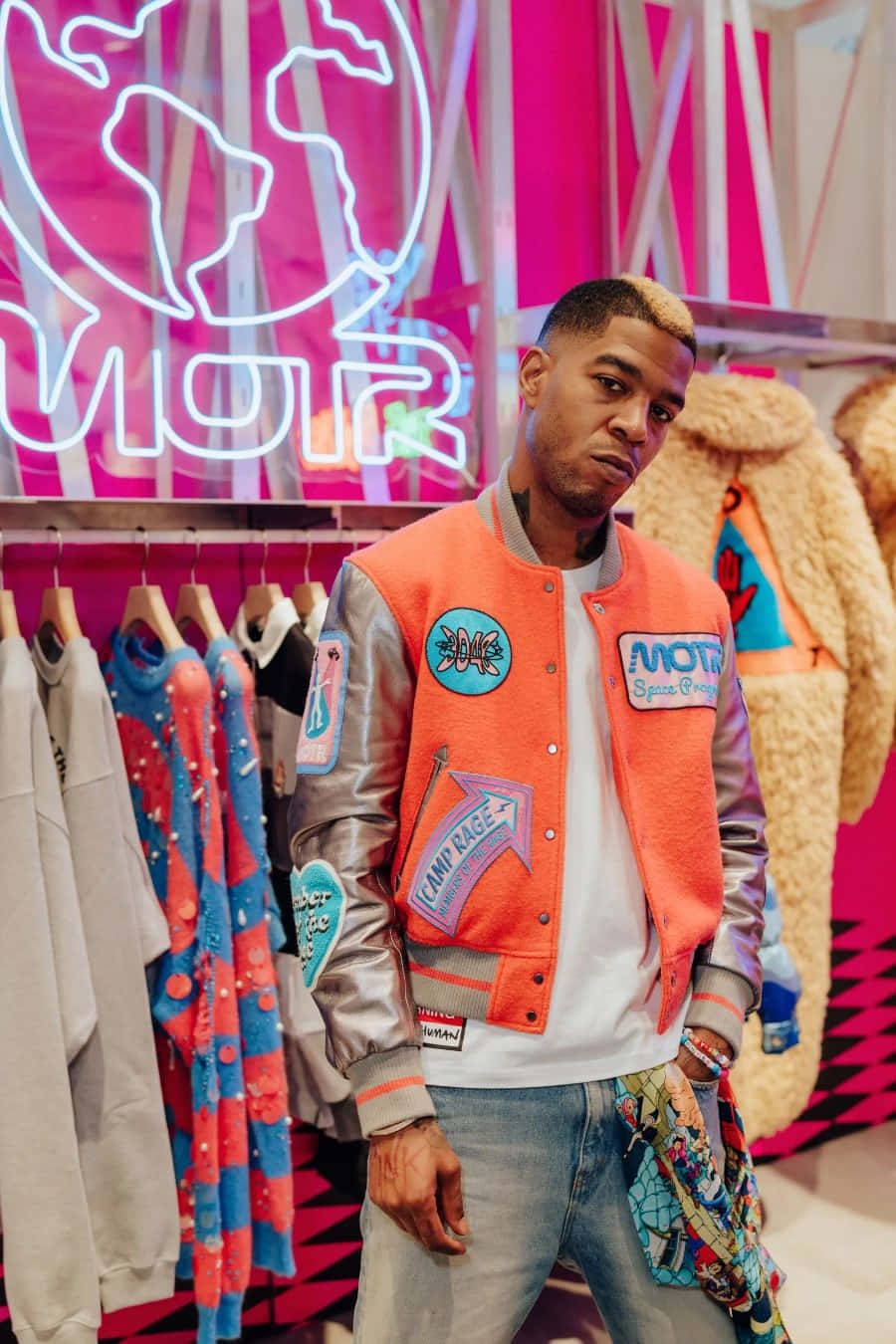 Kid Cudi Stylish Varsity Jacket Neon Backdrop Wallpaper