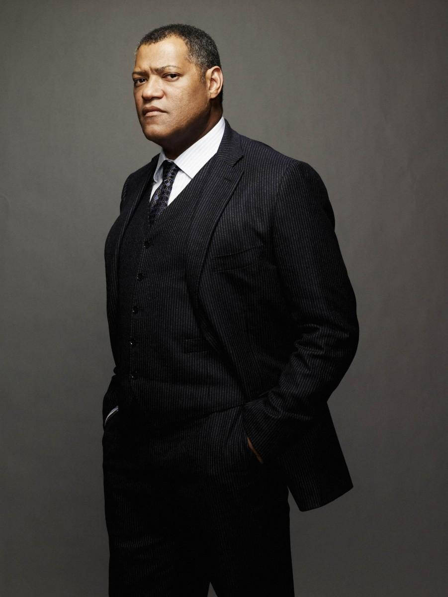 Laurence Fishburne In Casual Attire Standing-confidently With His Hands In His Pockets Wallpaper