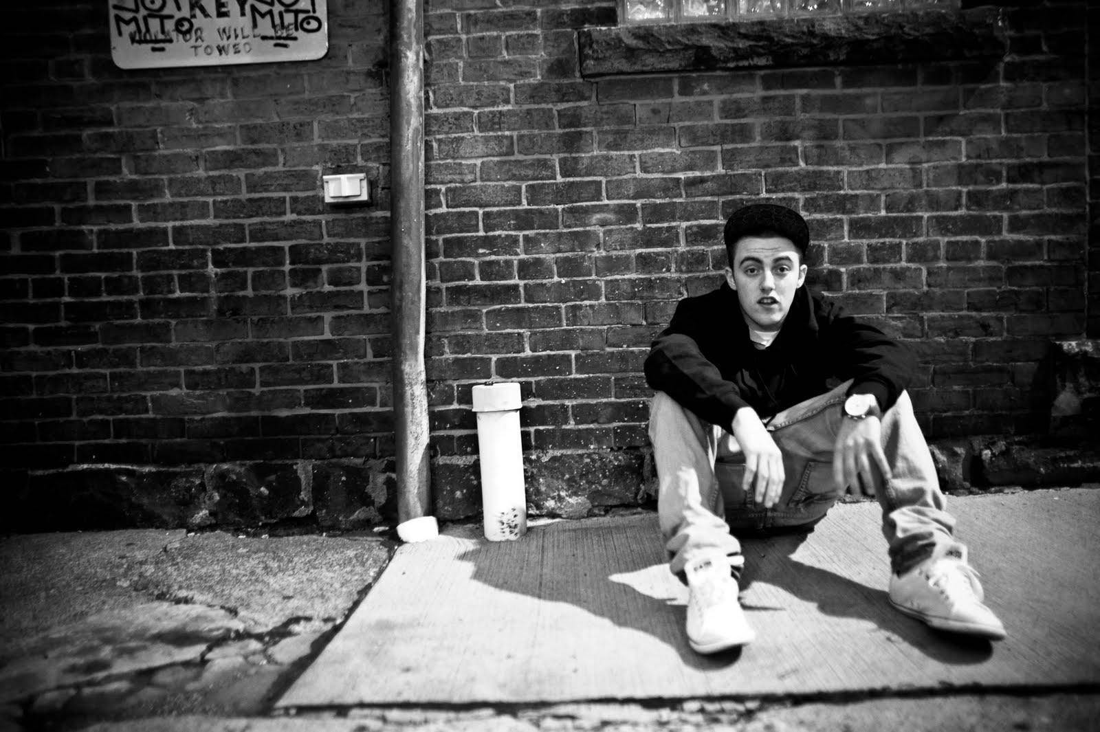 Mac Miller Leaning On Brick Wall Wallpaper