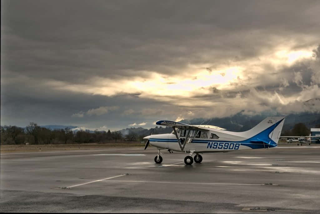 Majestic Small Airplane Resting On Airport Ground Wallpaper