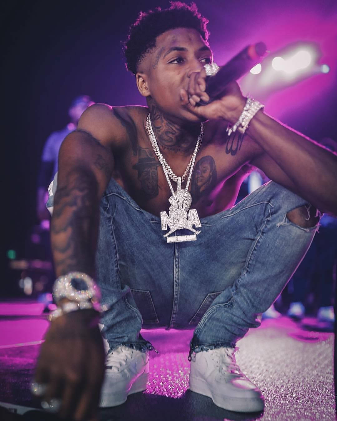 Nba Youngboy Appearing On Purple Neon Lights Stage Wallpaper