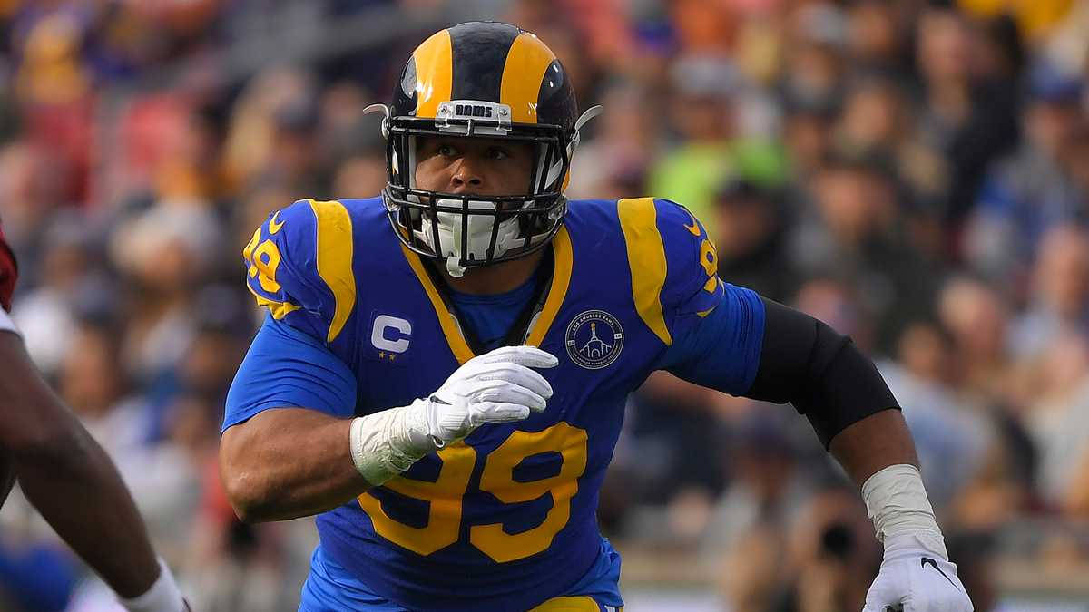 Nfl Aaron Donald Running Football Fiield Wallpaper