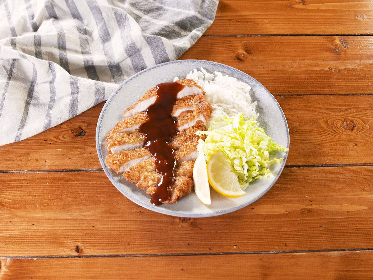 Plate Of Saucy Tonkatsu On Wooden Surface Wallpaper