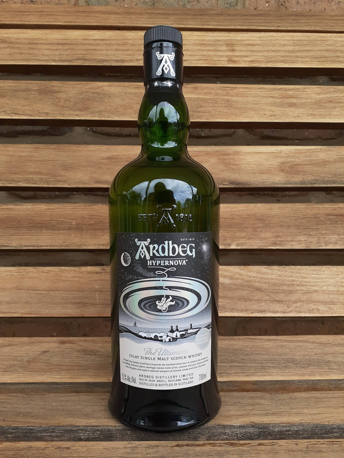 Prestigious Ardbeg Hypernova Whisky On Classic Wooden Bench Wallpaper