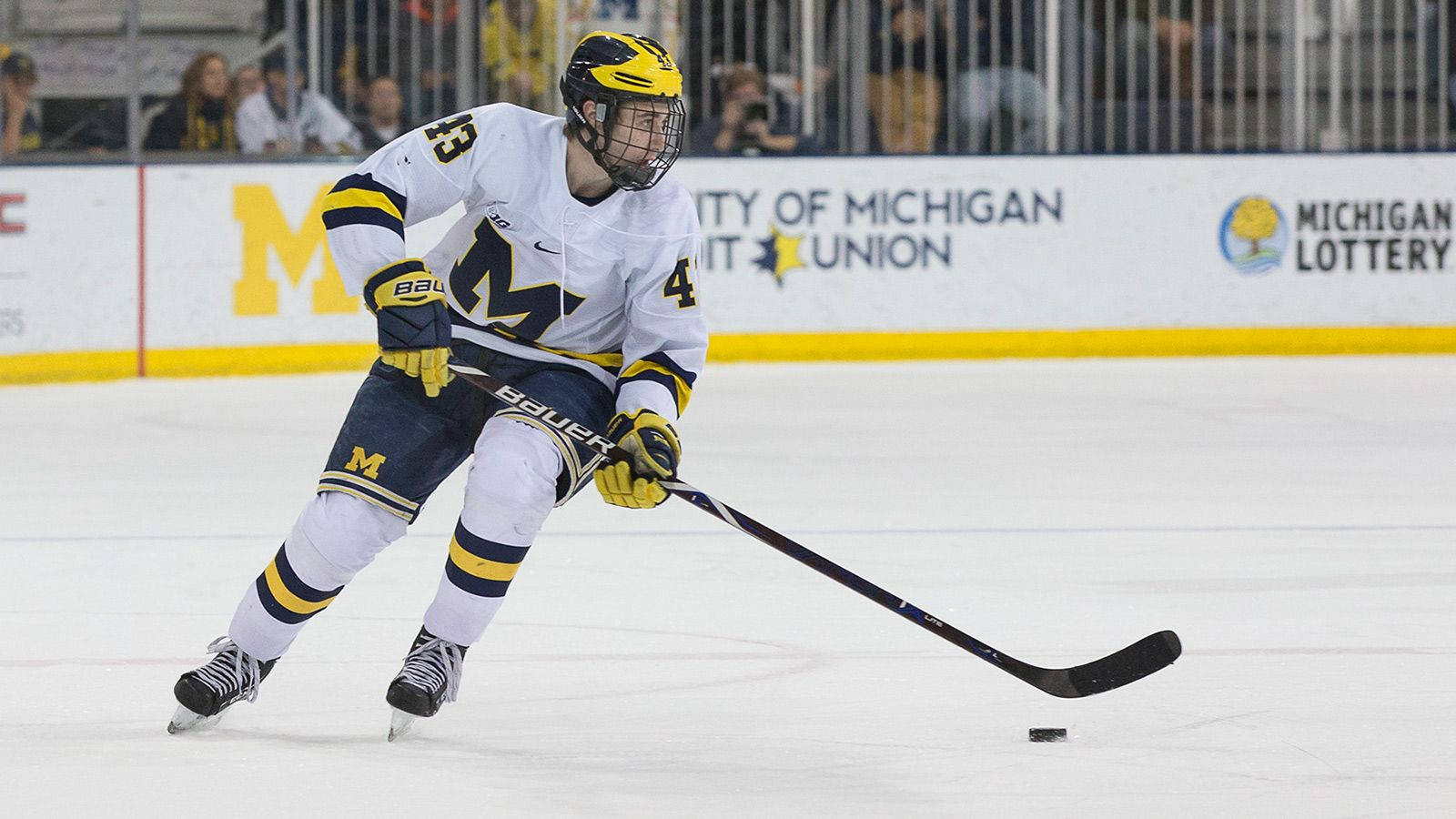 Quinn Hughes Dribbling Hockey Puck With Hockey Stick During Game Wallpaper