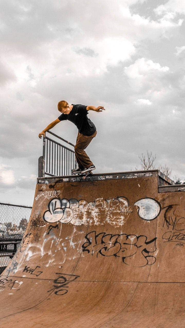 Riding High: A Skateboarder In Action At The Aesthetic Skatepark Wallpaper