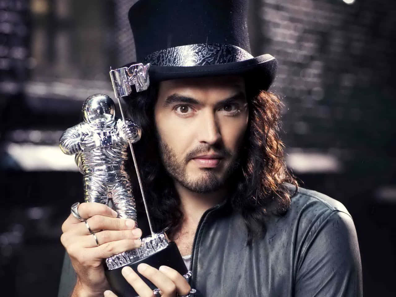 Russell Brand Triumphantly Holding An Mtv Award Trophy Wallpaper