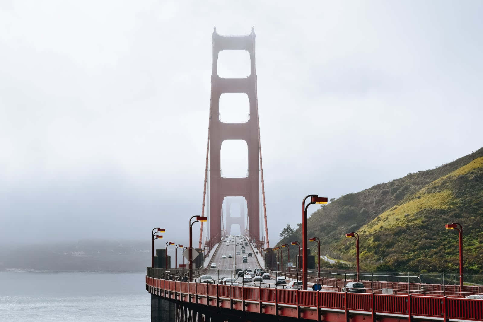 San Francisco’s Iconic Fog Rolling Over The Bay Bridge. Wallpaper