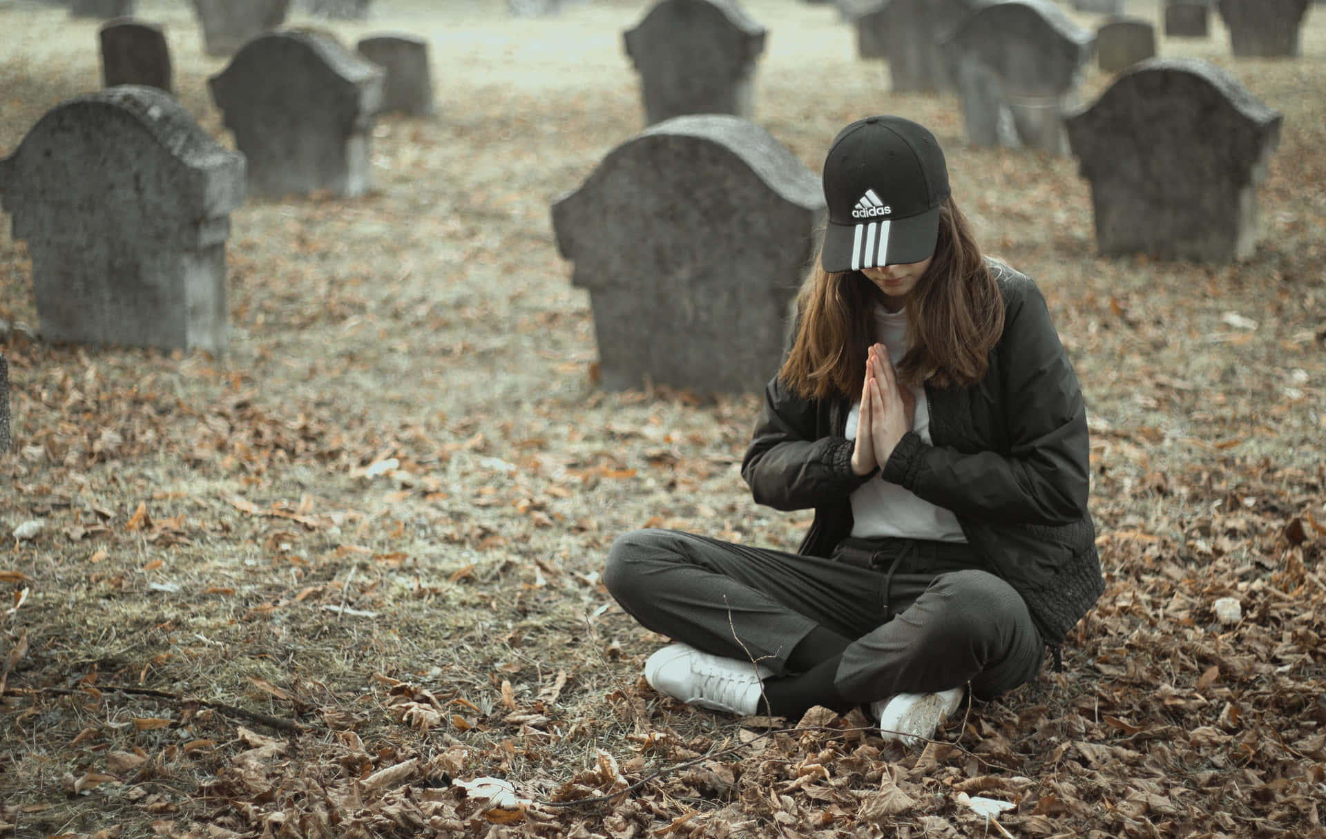 Serene Woman Praying In Cemetery Wallpaper