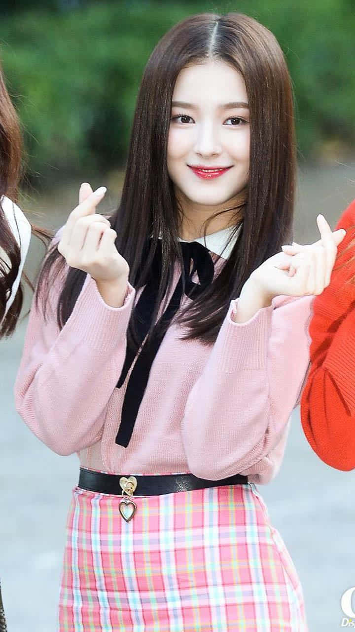 Smiling Woman Finger Heart Gesture Wallpaper