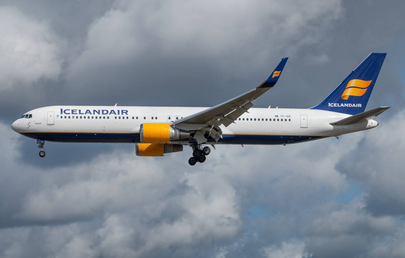 Soaring Icelandair Airplane Under The Dark Clouds Wallpaper