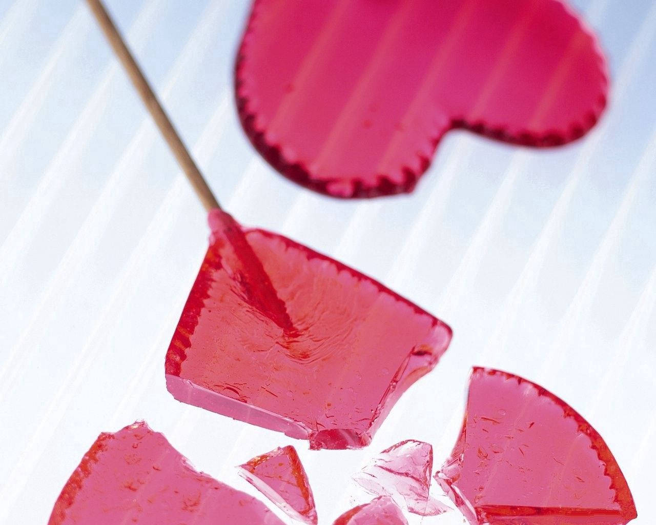 Sweet But Broken - A Red Heart-shaped Lollipop Wallpaper