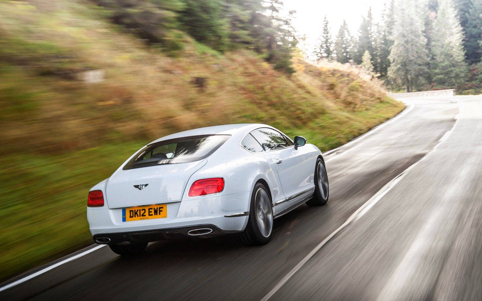 Take The Road In Style: A Rear View Of A White Bentley Continental Gt Wallpaper