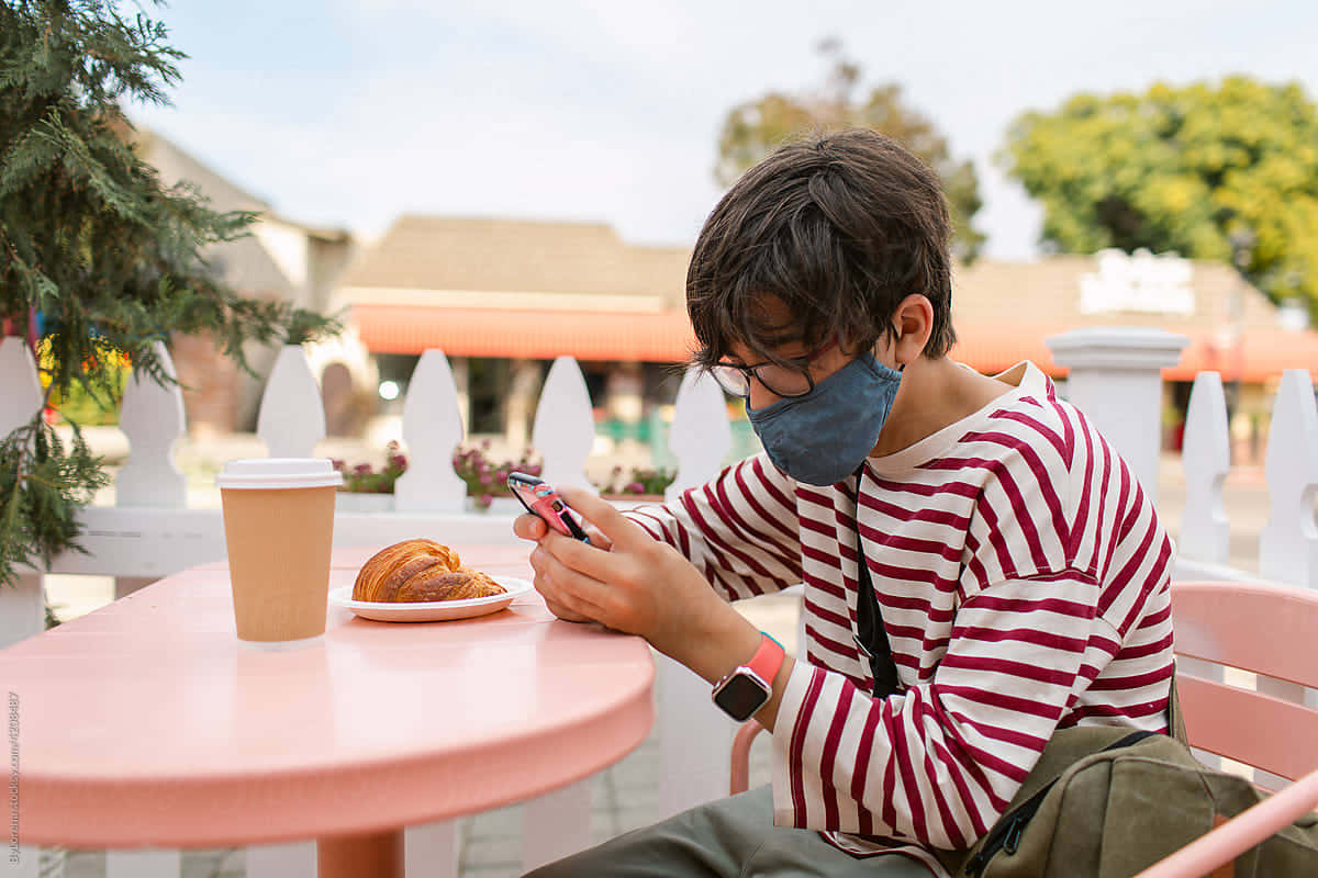 Teen Boy Using Smartphone Outdoors Wallpaper