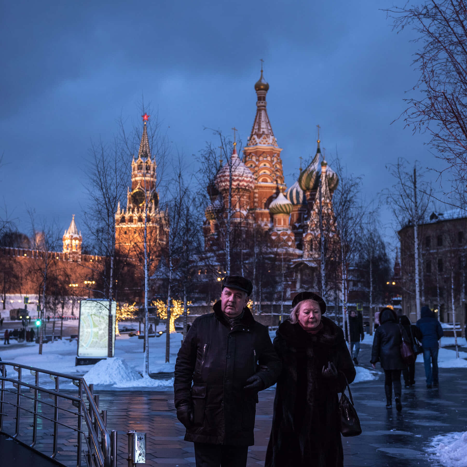 Two People Standing In Front Of A Building In The Snow Wallpaper