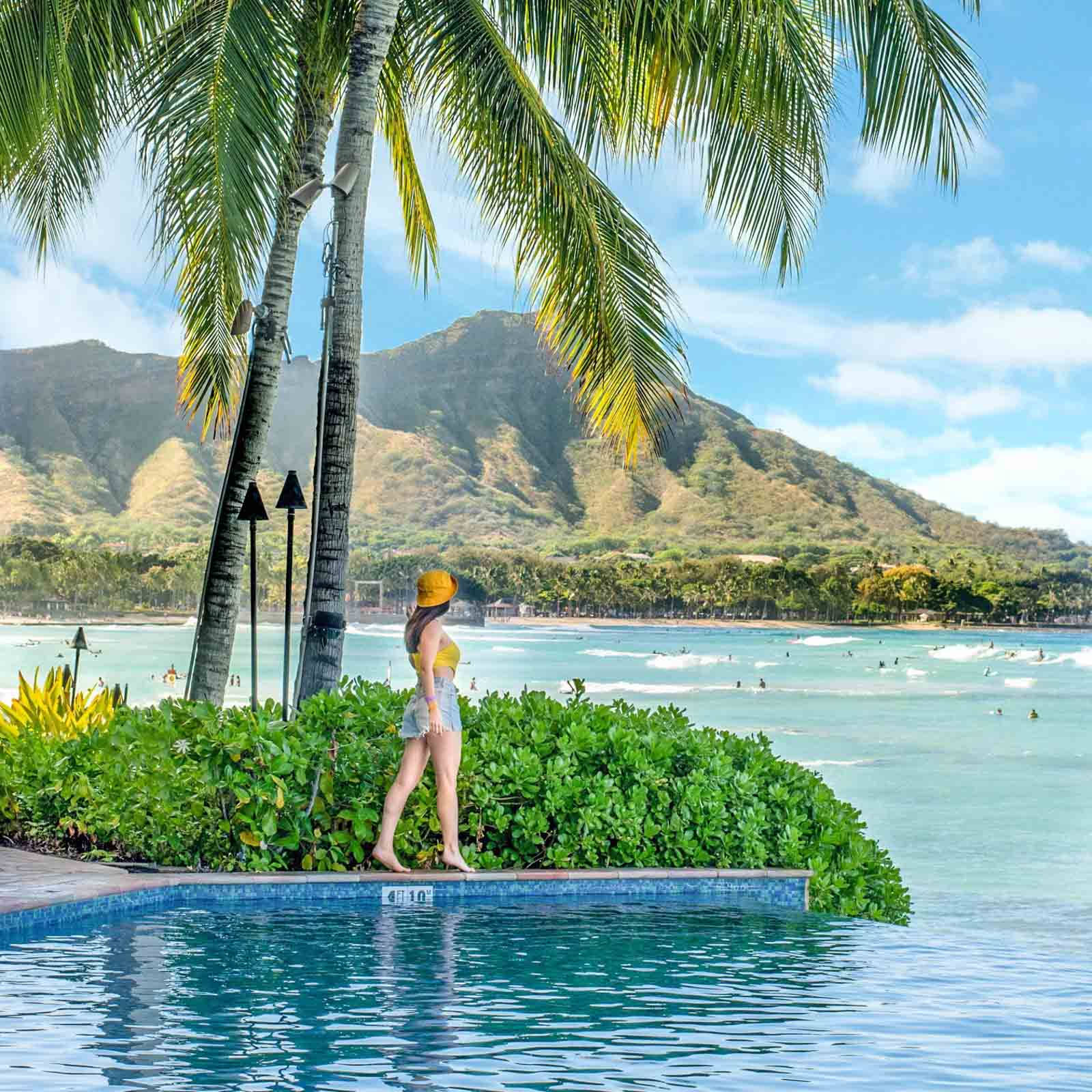 Woman Standing By Pool In Oahu Wallpaper