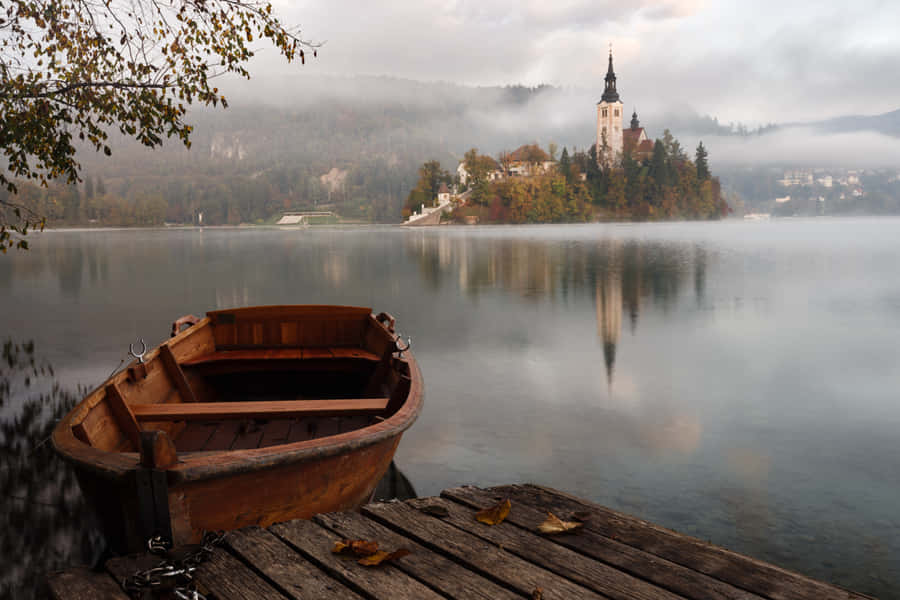 A Boat Docked At A Quay In Lake Bled Wallpaper