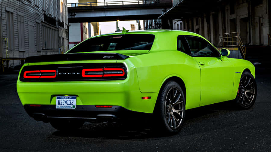 A Green Dodge Challenger Parked On A Street Wallpaper