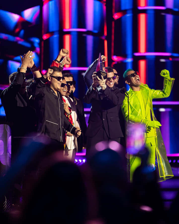 A Group Of Men In Suits On Stage Wallpaper