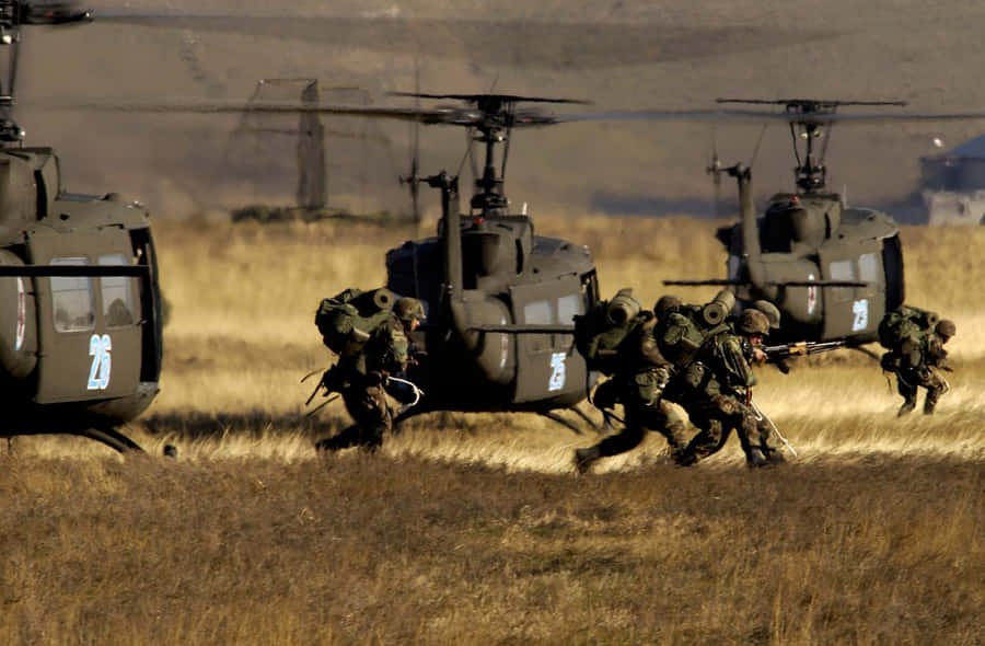 A Group Of Soldiers Running Through A Field Wallpaper