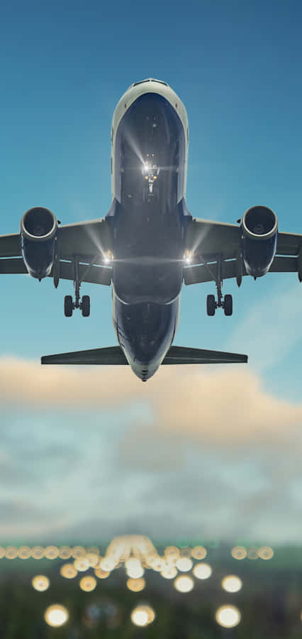 A Large Airplane Flying Over The City Wallpaper