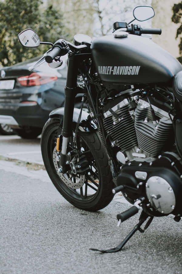 A Man Cruises On His Cruiser-style Hd Motorcycle In The Mountains Wallpaper