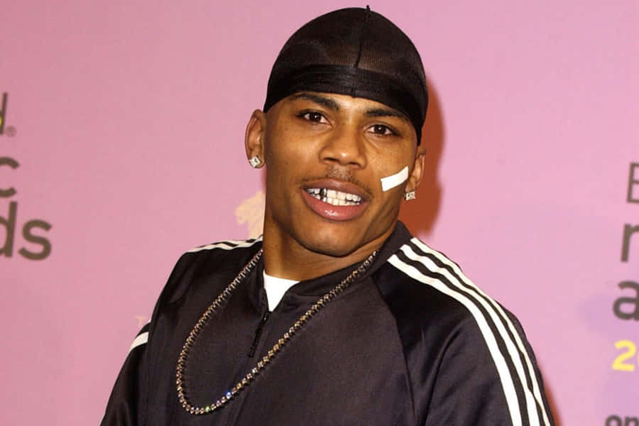 A Man In A Black Jacket And Hat Is Smiling Wallpaper