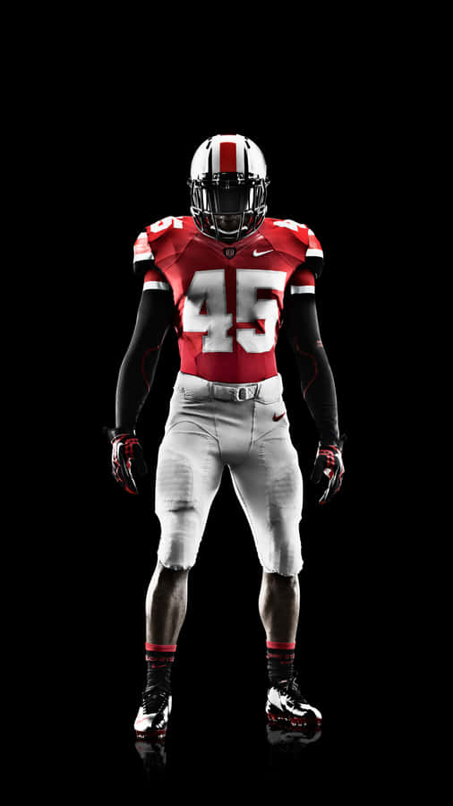 A Man In A Football Uniform Standing On A Black Background Wallpaper