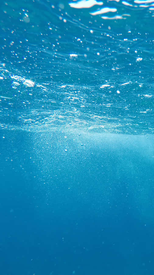A Man Is Swimming In The Ocean Wallpaper