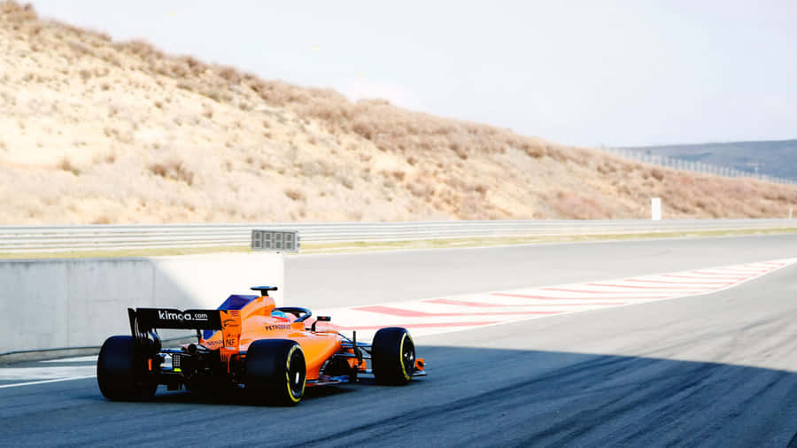 A Racing Car Driving Down A Track Wallpaper