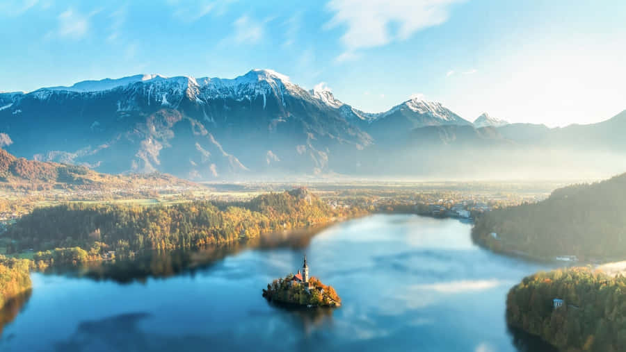 A Stunning View Of The Julian Alps Peak With Lake Bled In The Background Wallpaper