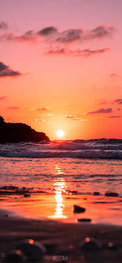 A Sun-kissed Sunrise On A Beach, Perfect For A Scenic Iphone Wallpaper Wallpaper