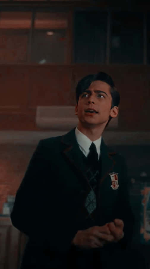 A Young Man In A Suit And Tie Is Standing In A Room Wallpaper