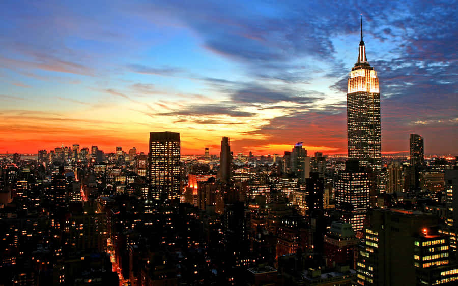 Bright City Lights Illuminate A Nighttime Urban Skyline Wallpaper