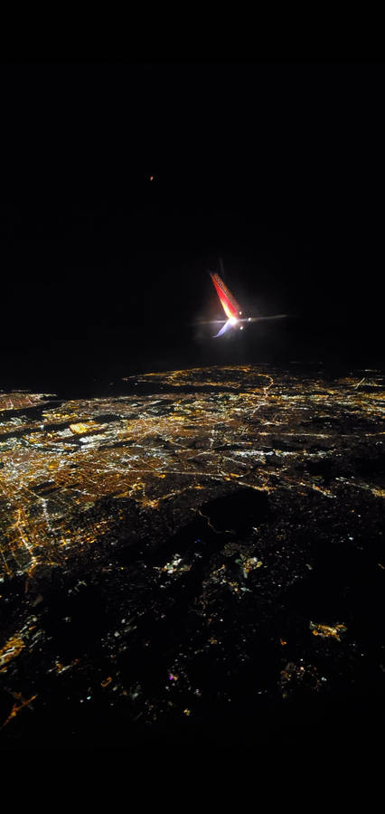 City's Night Scene Viewed From A Plane Window Wallpaper