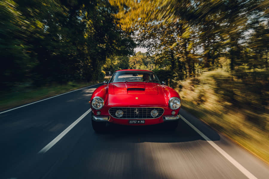 Driving In Style - A Classic Ferrari On The Open Road Wallpaper